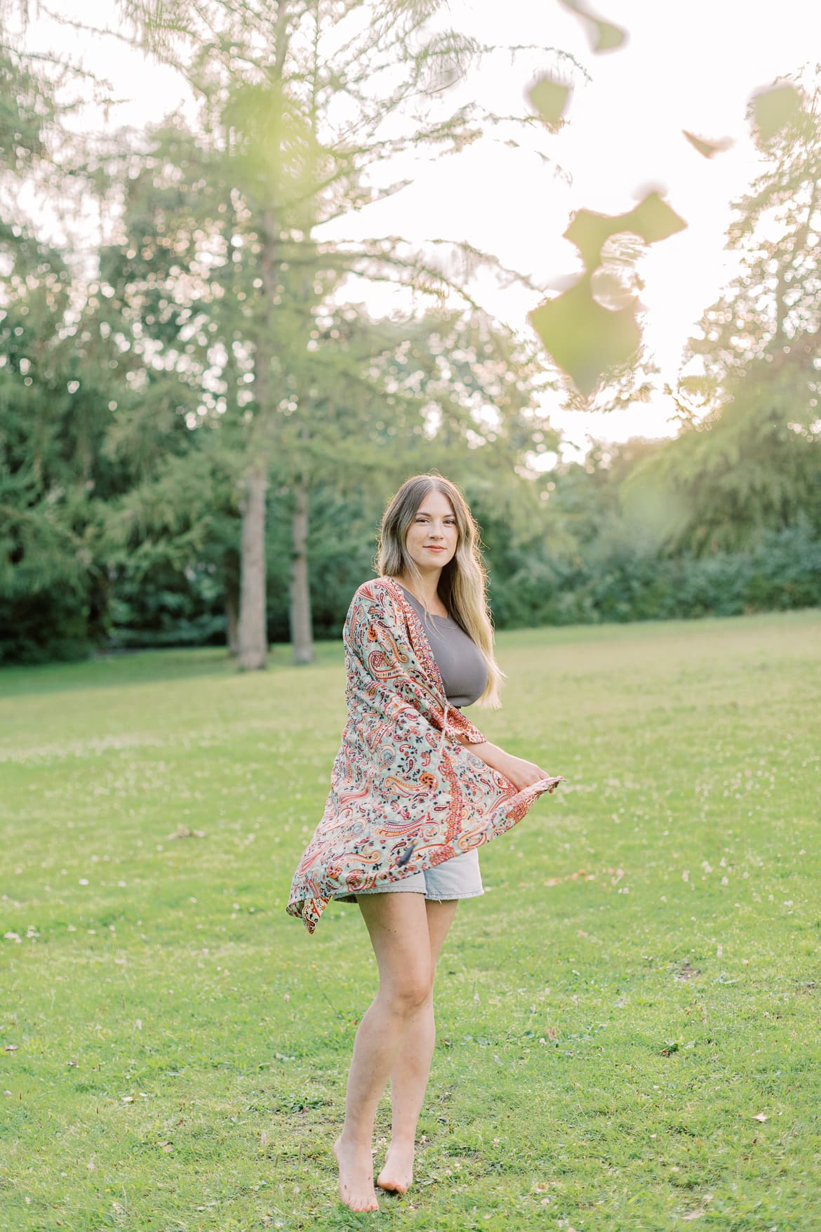 Frau mit blonden Haaren und Kimono in der Abendsonne im Park