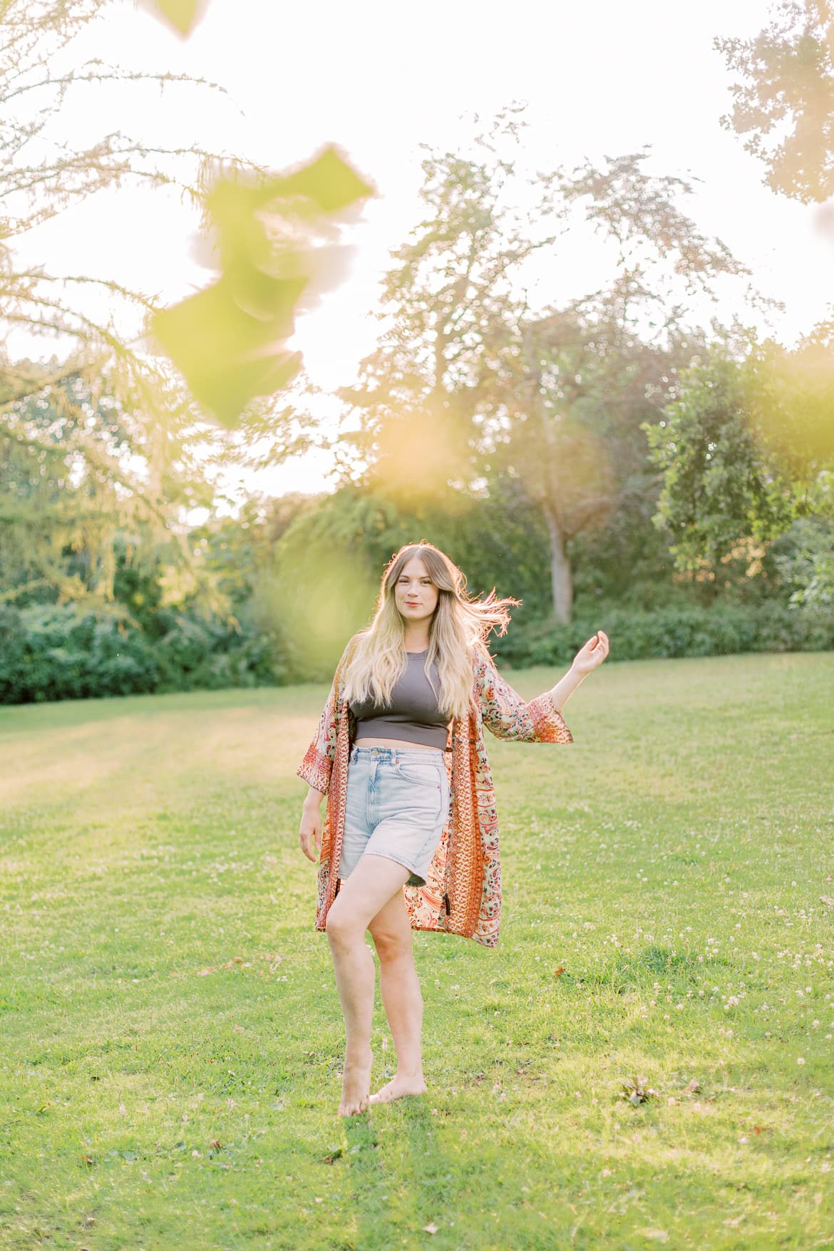 Frau mit blonden Haaren und Kimono in der Abendsonne im Park