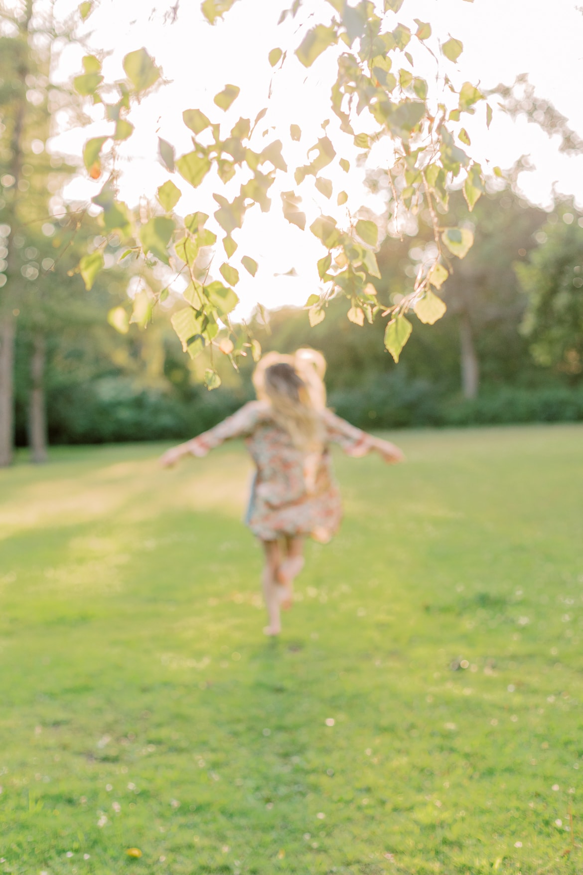 Frau mit blonden Haaren und Kimono in der Abendsonne im Park