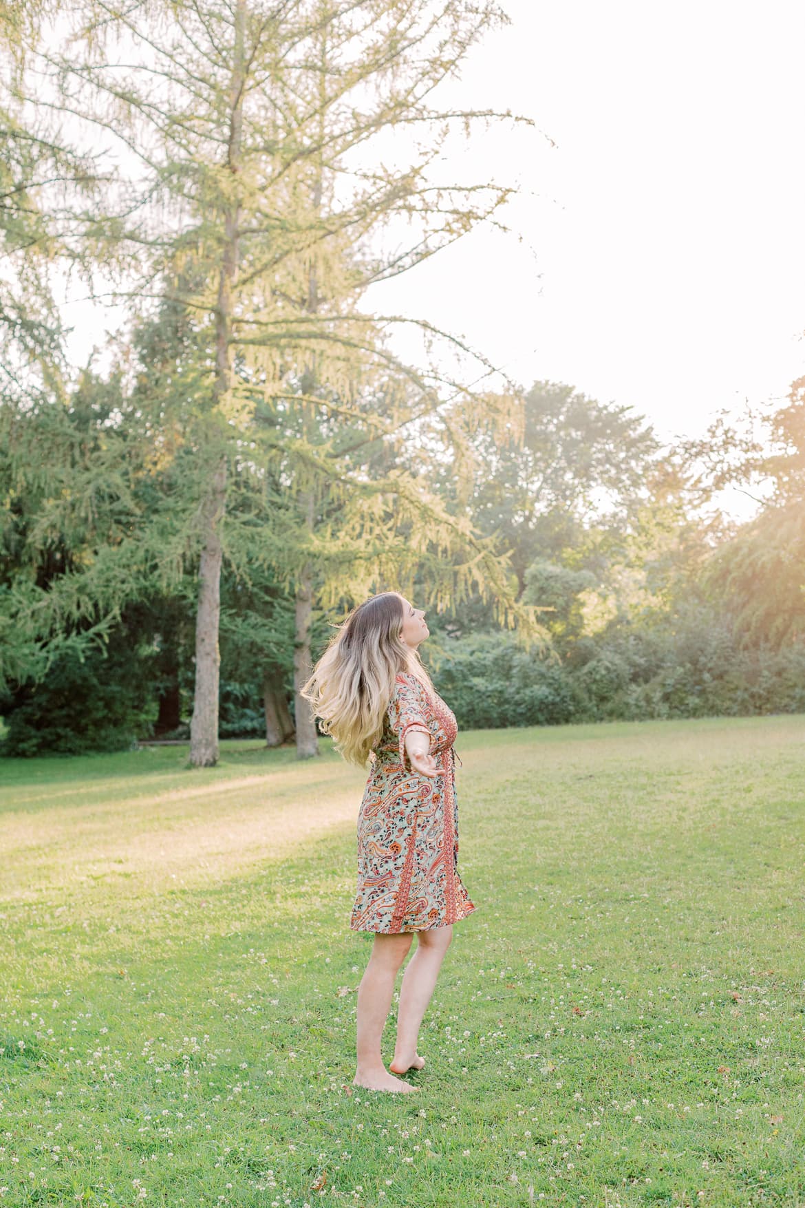 Frau mit blonden Haaren und Kimono in der Abendsonne im Park