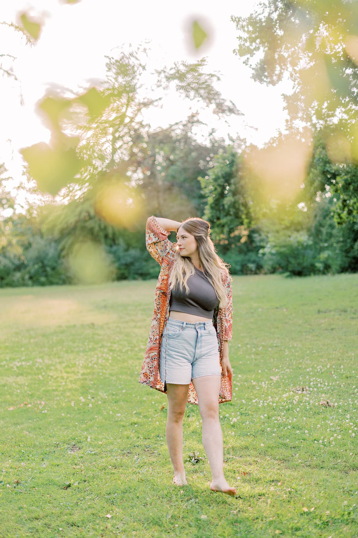 Frau mit blonden Haaren und Kimono in der Abendsonne im Park