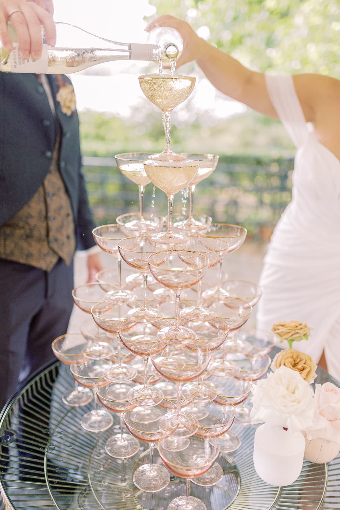 Hochzeitspaar befüllt den Champagnerturm