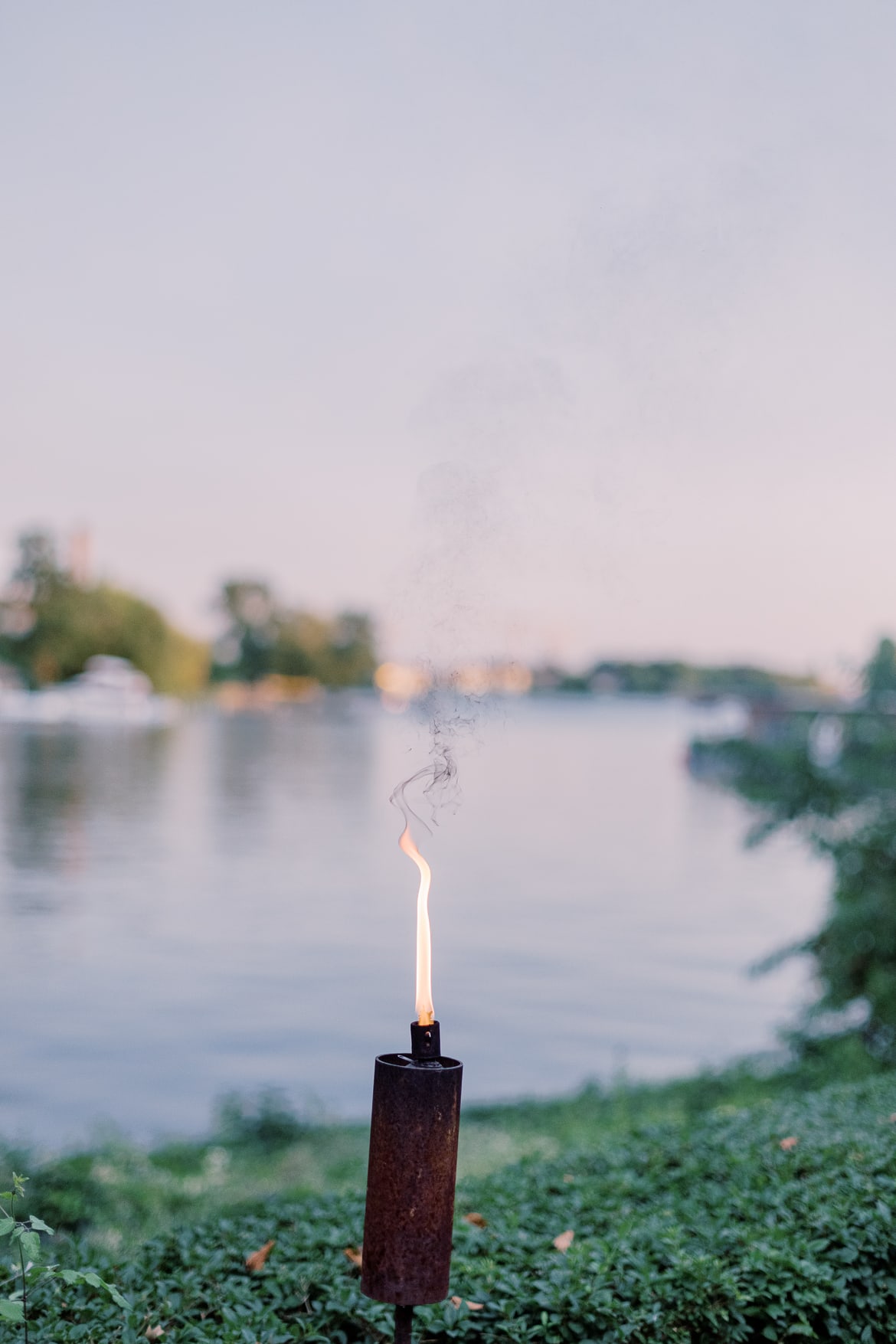 Eine Fackel am Abend mit Blick auf das Wasser