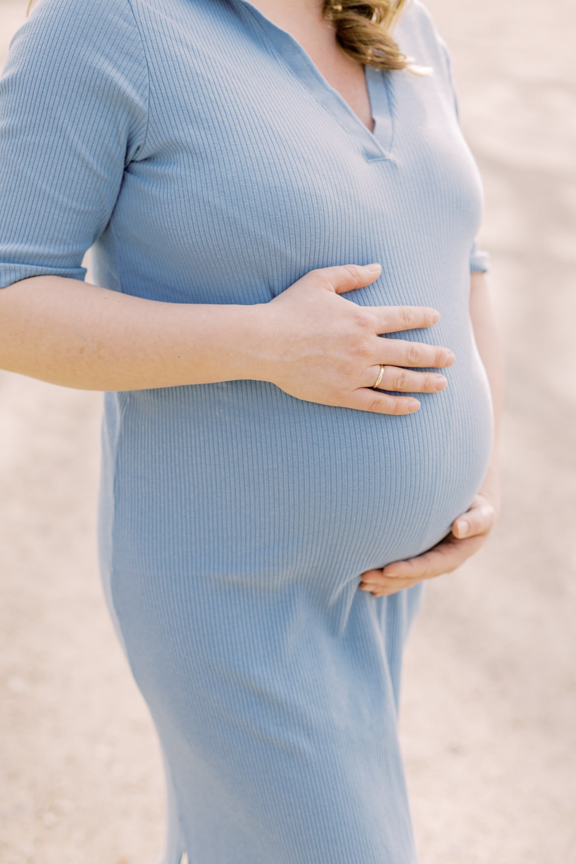 Man sie den Babybauch einer Frau und wie sie ihre Hände darauf legt